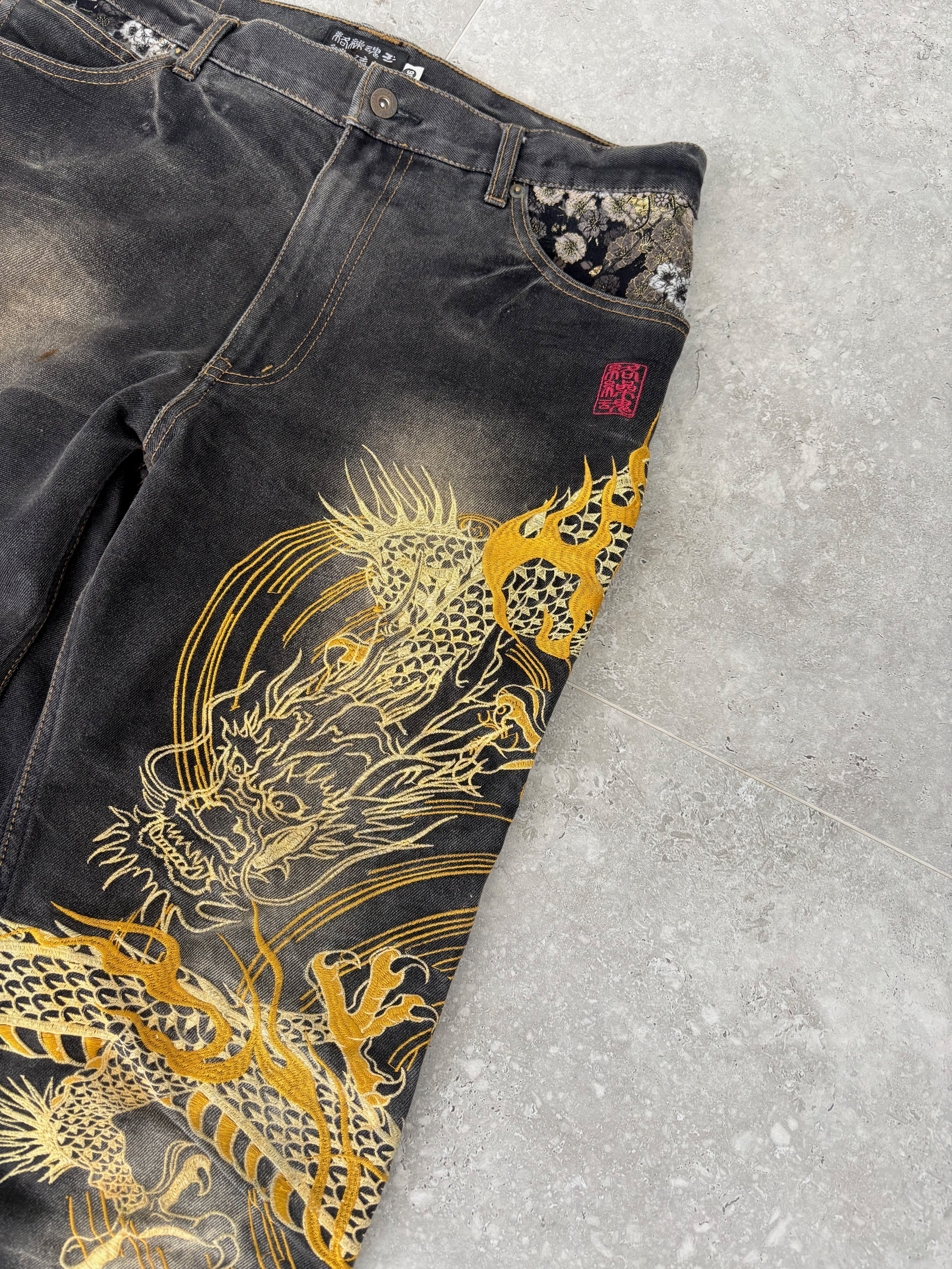 Karakuri black tab jeans with full dragon embroidery. Size 34–36.
